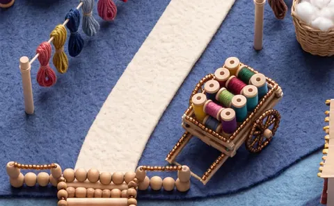 Loom: a dye town of vats and skeins, a loom at the gate.